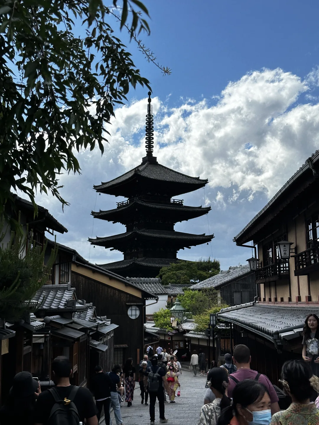 Jalan dengan bangunan tradisional dan pagoda tinggi di antara pengunjung