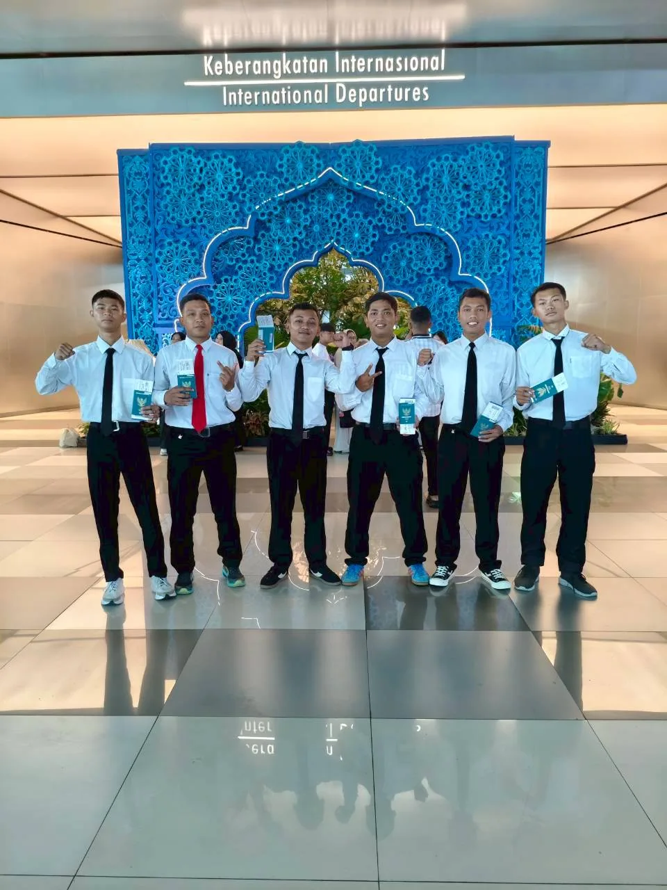 Enam siswa dengan kemeja putih berfoto bersama di bandara