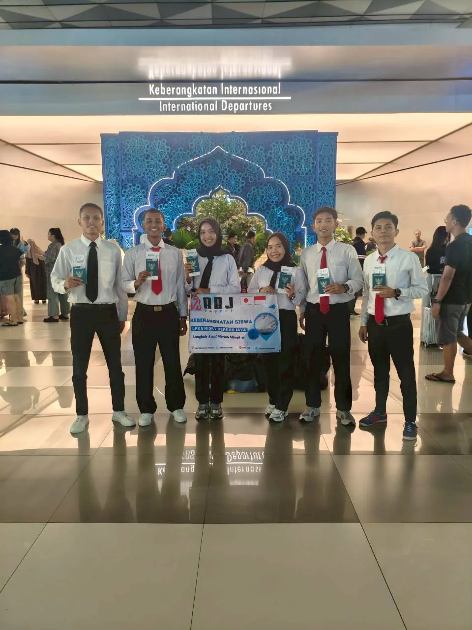 Enam siswa berfoto dengan spanduk keberangkatan RBJ di bandara